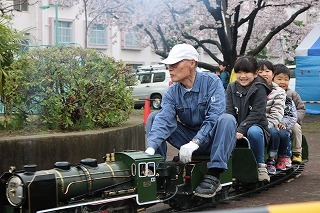 老人と子供たちがミニSLに乗っている