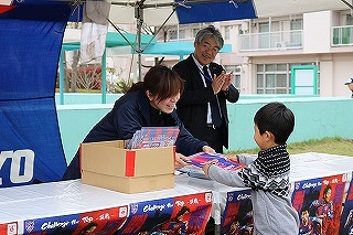 大人が子供に景品を渡している