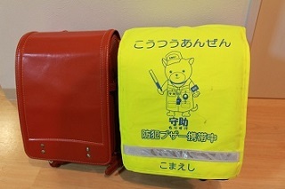 目立つ反射板付きの黄色いランドセルカバーの写真
