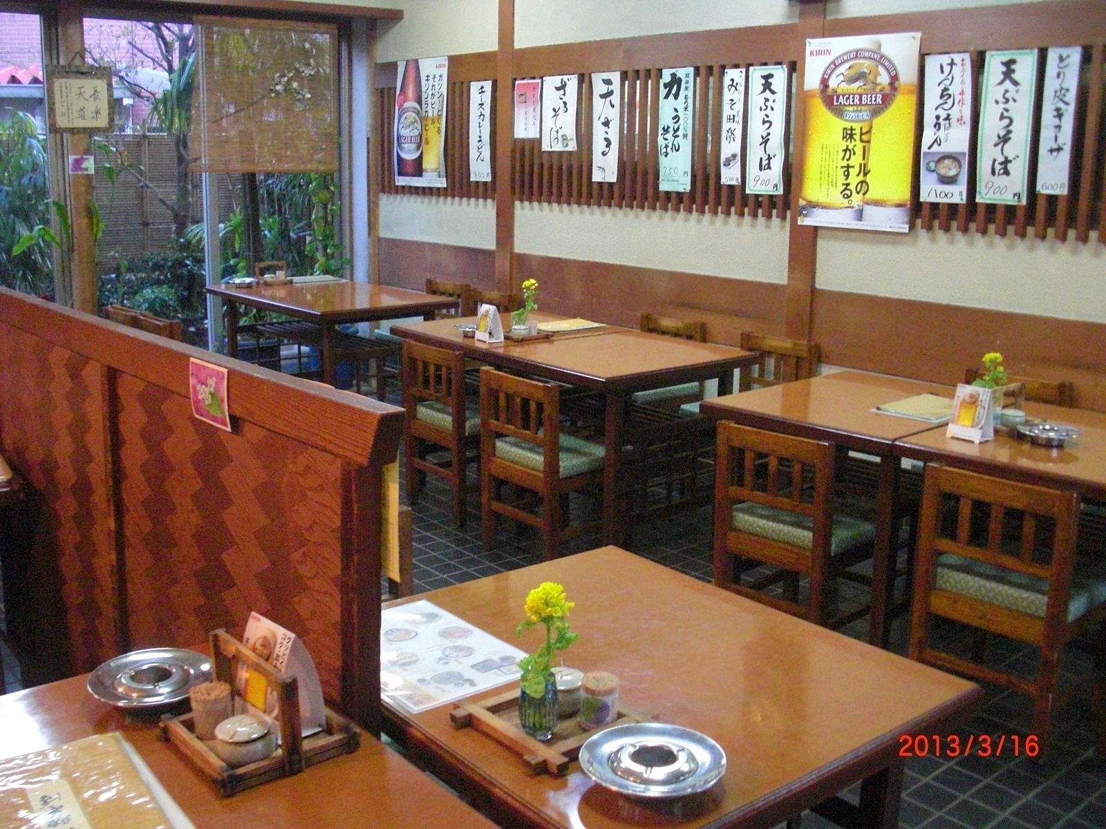 席ごとに一輪挿しが飾られているテーブル席の写真