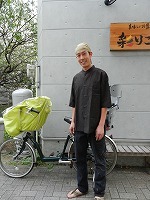 自転車の前に立つケイスケさんの写真