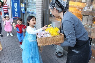 ちいさなパンの木でお菓子を貰う子供たちの様子