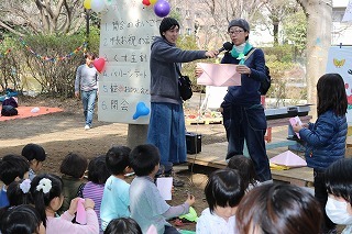 大きな折り紙でのお手本を見ながら折り紙を楽しむ子供たちの様子