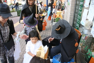 子供にお菓子を配る店主の様子