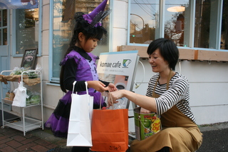 魔女の仮装をした女の子がお菓子を受け取る様子