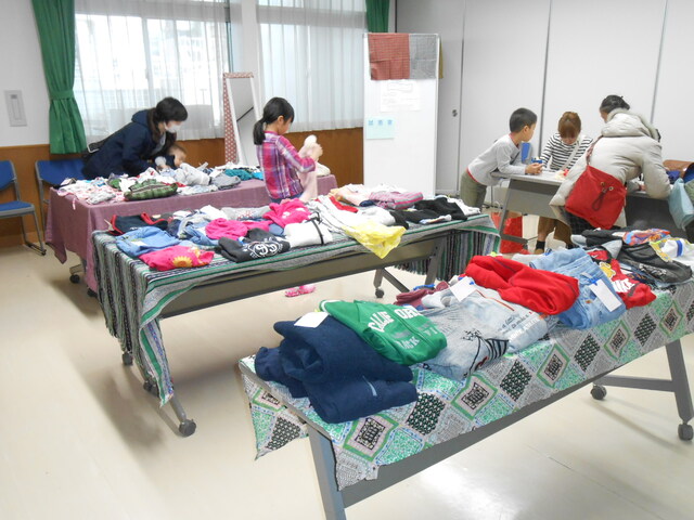 机の上に服がたくさん並んでいる様子