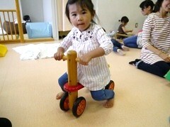 バイクのおもちゃにまたがっている赤ちゃんの写真
