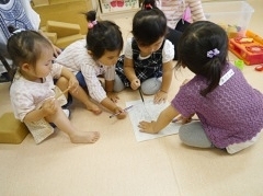 ４人の子どもたちが紙の周りに集まっている様子