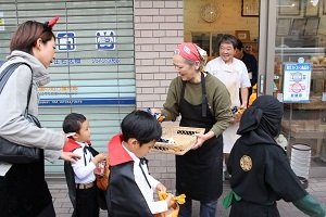パン屋さんが子供たちにパンを配っている写真