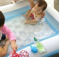 赤ちゃんがビニールプールで水遊びする様子