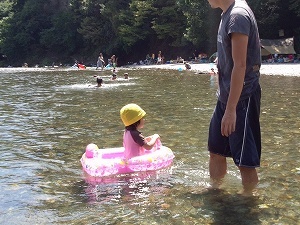 川で水遊びをしている親子の写真